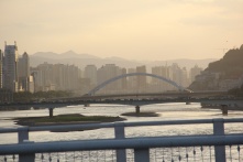 The Yellow River is surrounded by apartment blocks and spanned by bridges.